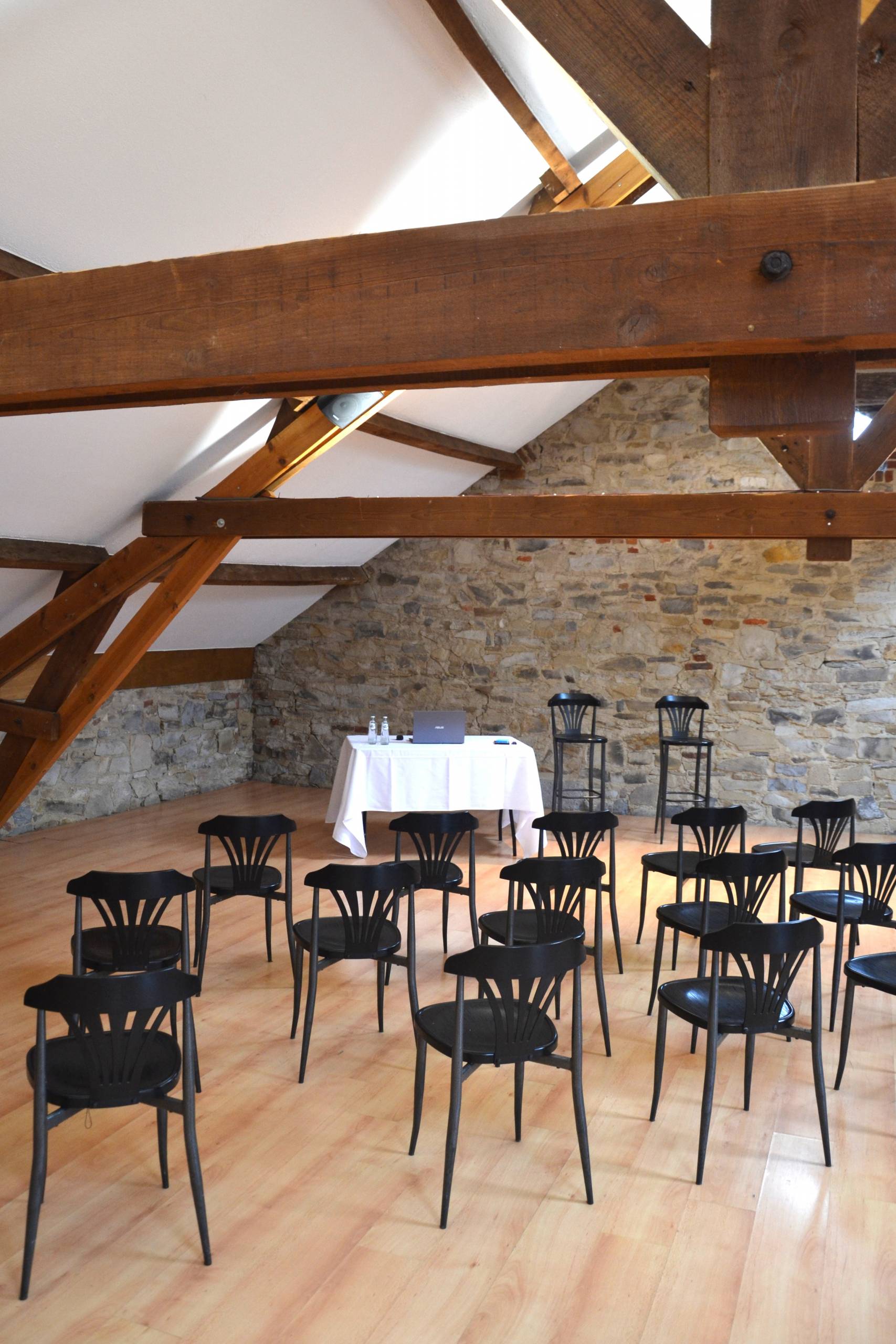Le Grenier sous sa charpente en bois, tables et chaises en place.